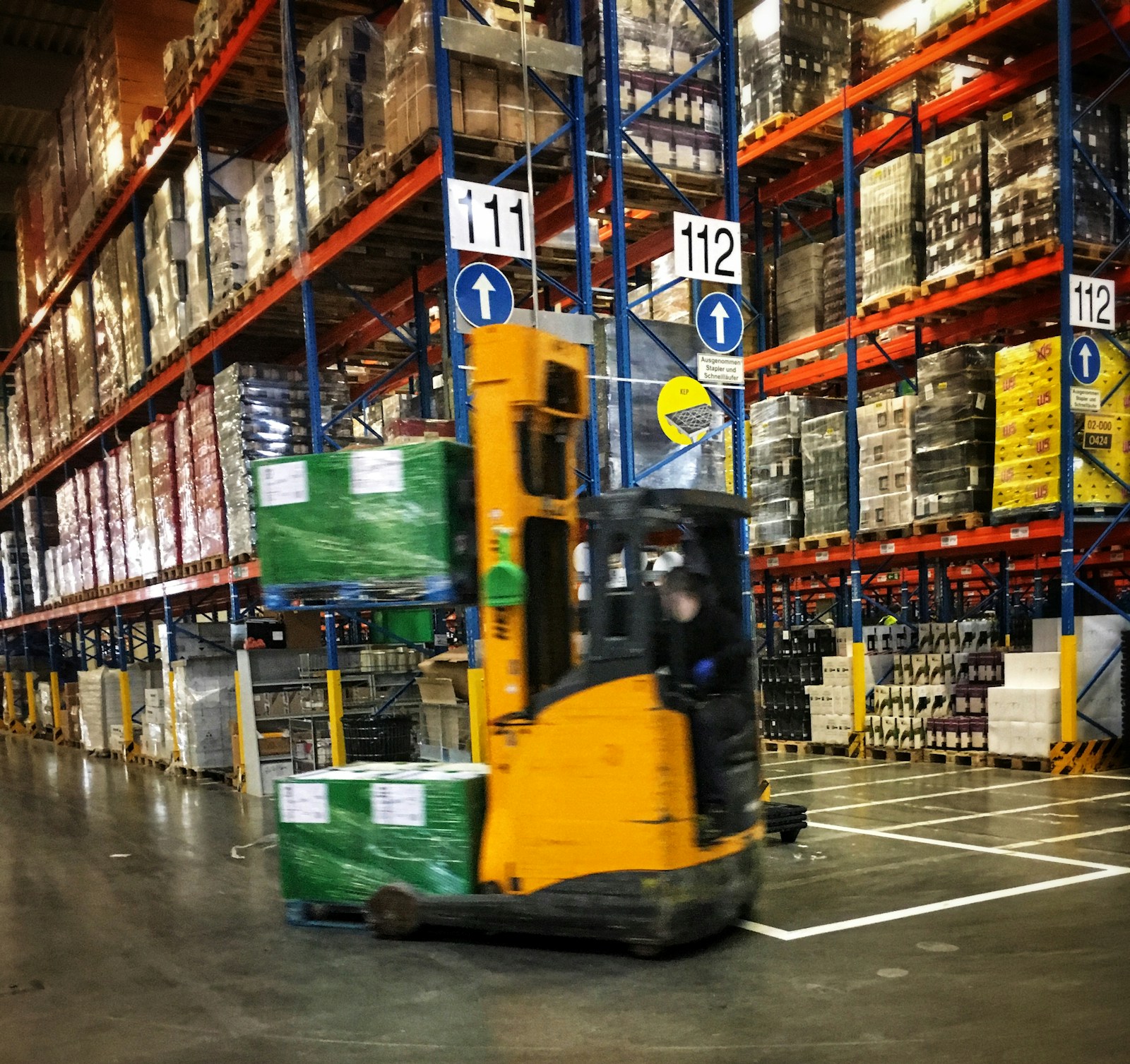 Forklift operating near racking in warehouse